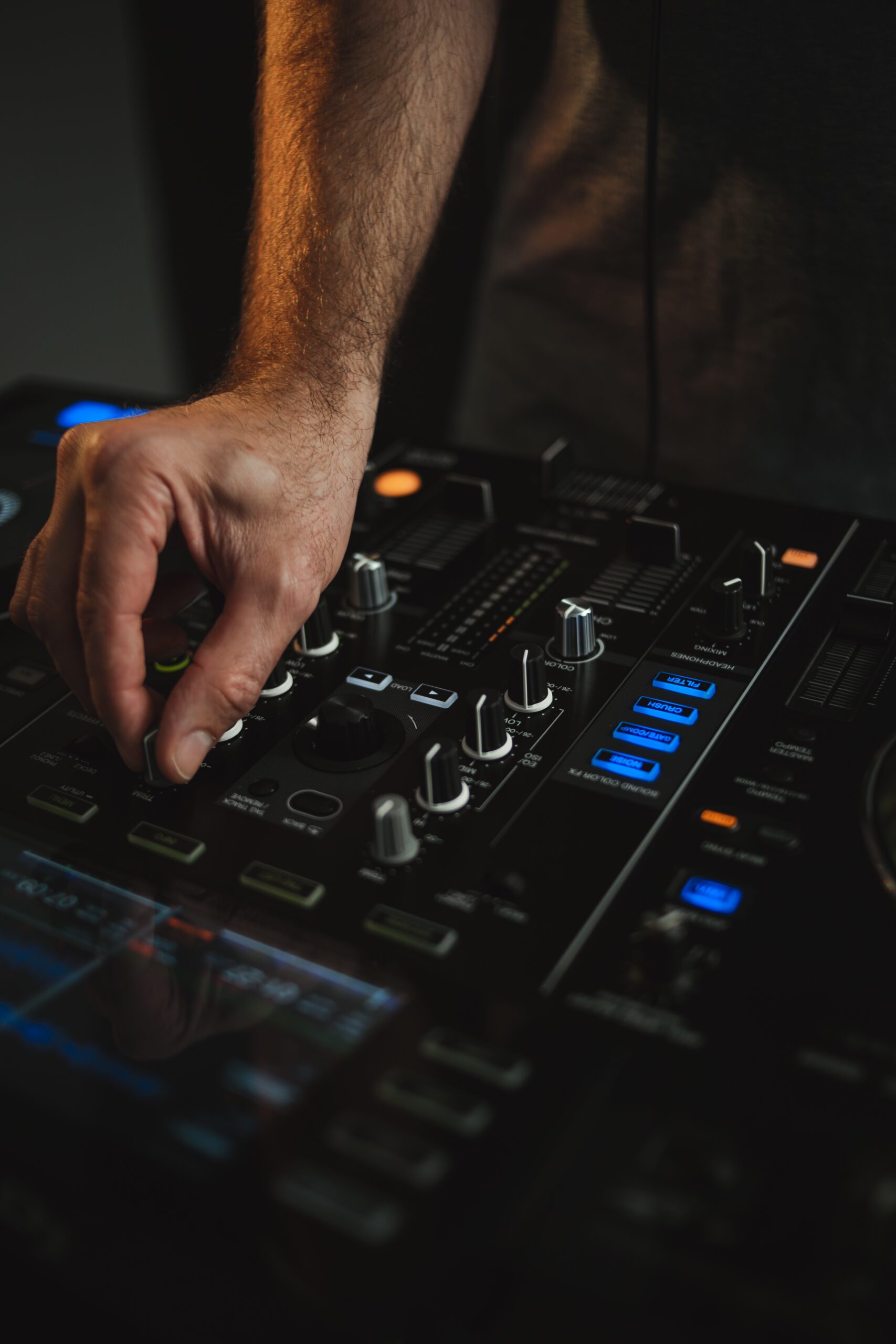 Vertical closeup of a DJ working in a studio with a blurry background